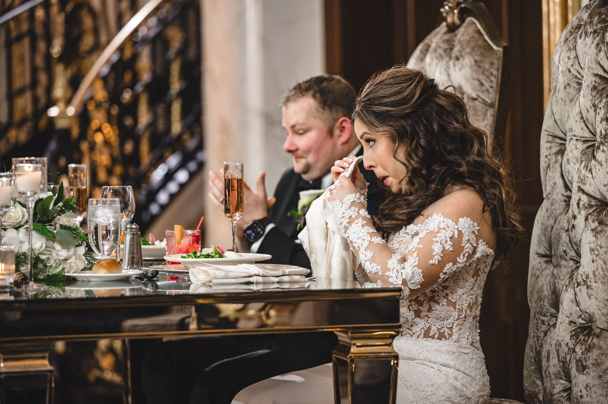 Wedding guests sharing laughter and conversation at an elegant reception dinner table.