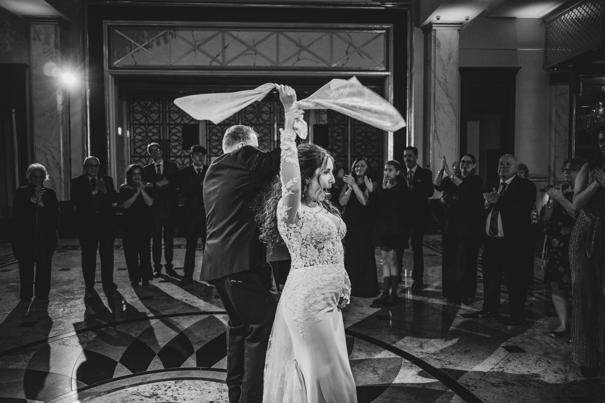 Black and white wide shot of an elegant wedding reception venue with decorative wall patterns.