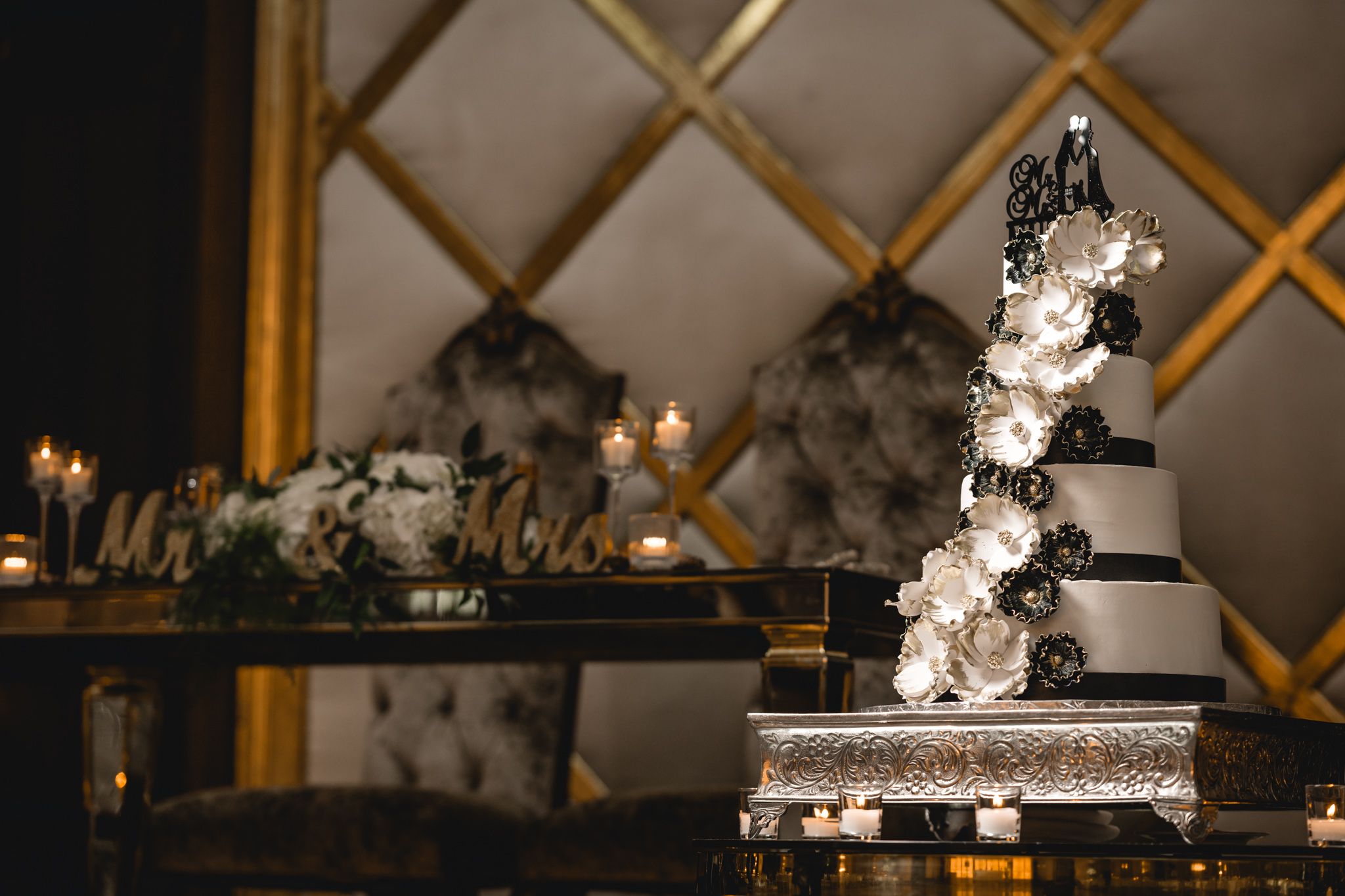 Modern geometric gold wall panels with decorative lighting and wedding signage.