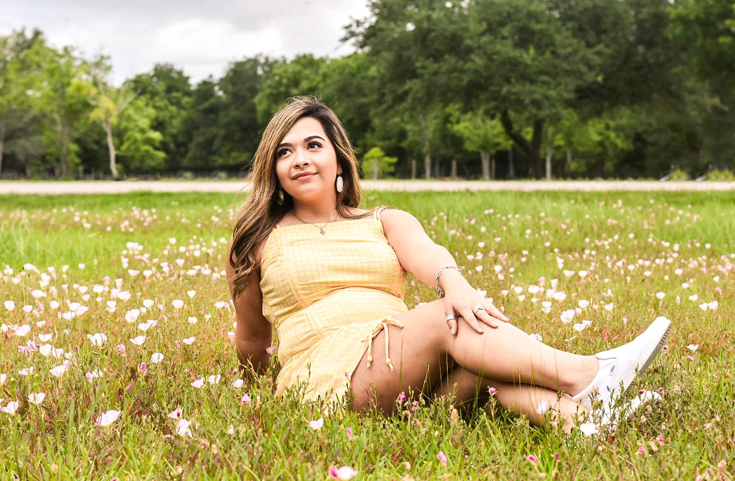 A yellow sundress in a wildflower field with white blooms on a sunny summer day.