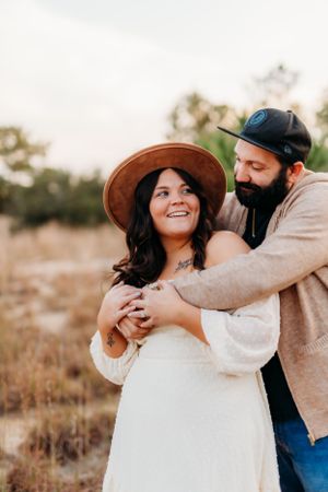 Couple embracing and laughing together during outdoor portrait session.
