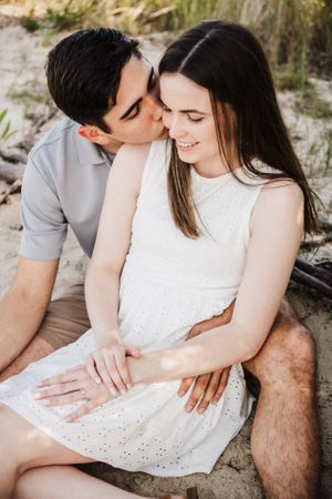 A sweet romantic moment between a couple during their beach engagement session.