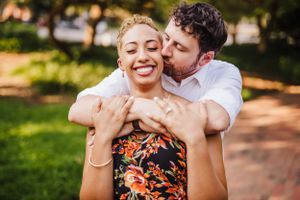Couple sharing loving embrace during outdoor summer photoshoot.