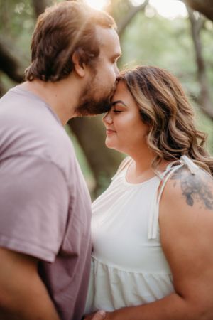 Intimate close-up photo of couple sharing a romantic moment outdoors.