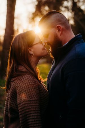 Romantic sunset engagement photo with golden backlight creating a dreamy atmosphere.