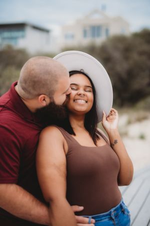 A candid moment of laughter and joy between a couple during their beach photoshoot.