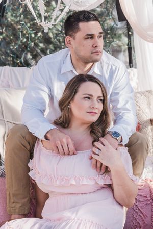 Intimate portrait in soft lighting under white draped canopy with pink decor.