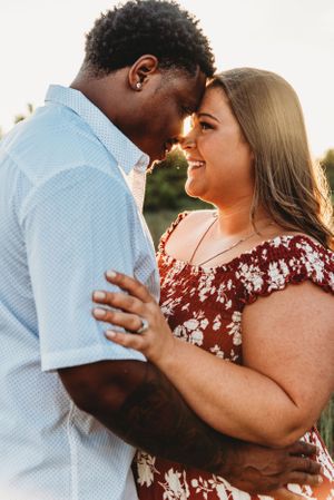 Interracial couple sharing an intimate romantic moment at sunset in casual summer outfits.