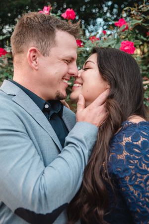 Romantic outdoor portrait in front of blooming pink roses.