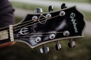 Close-up detail of a black Epiphone guitar headstock with tuning pegs.