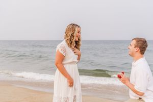 Seaside proposal scene with waves crashing in background.