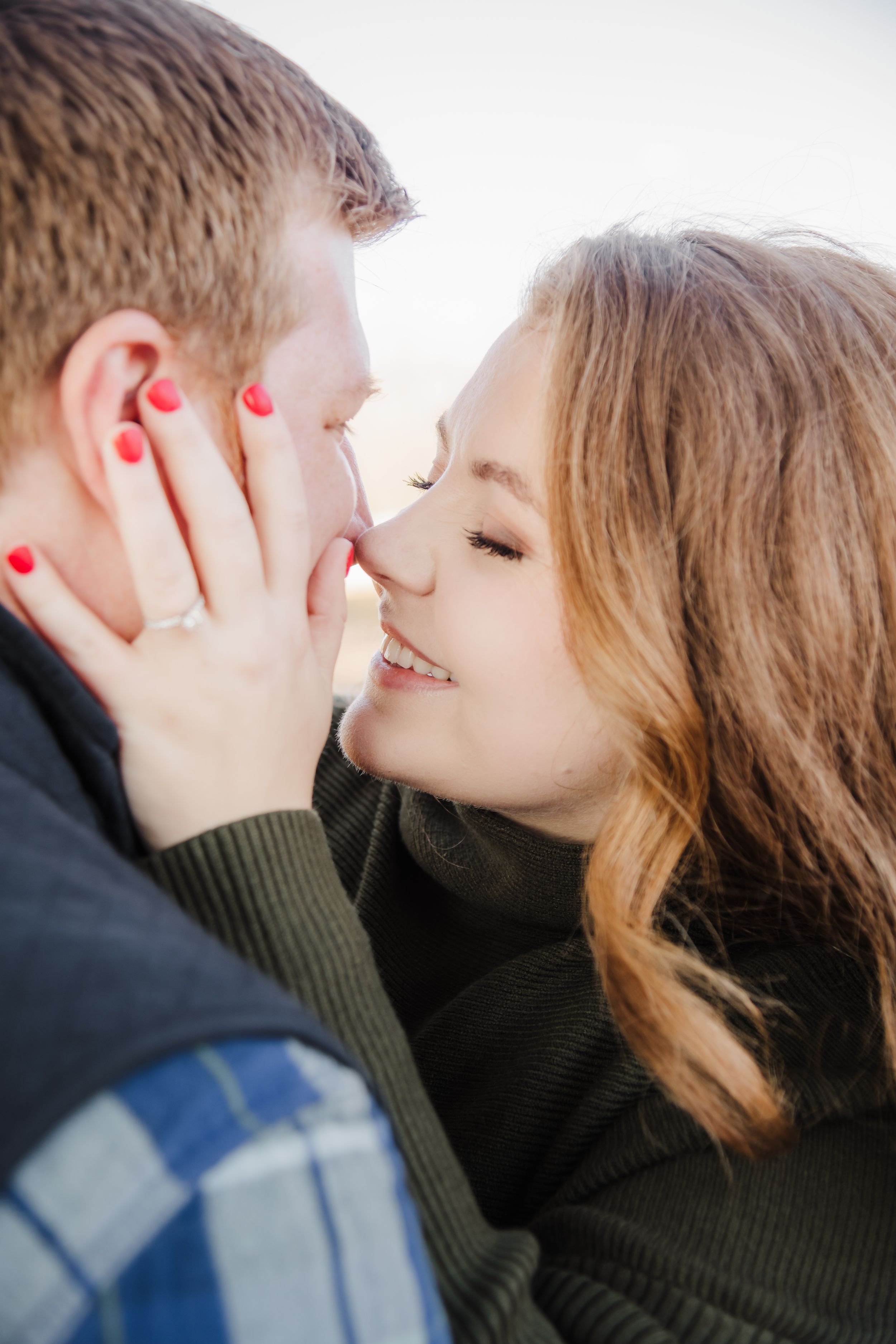 Close up intimate portrait of couple in dark winter clothing sharing tender moment.