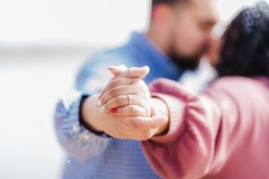 Couple holding hands during romantic engagement photo session.