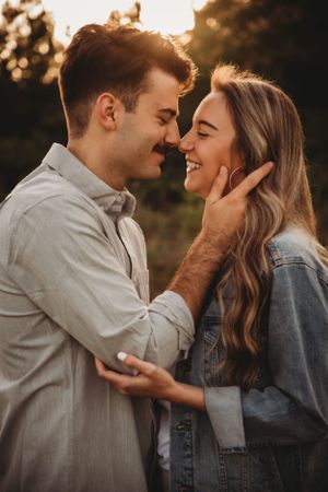 Intimate couple portrait capturing genuine laughter and tender moments at sunset.