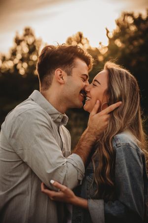 Romantic couple sharing an intimate moment during golden hour sunset.
