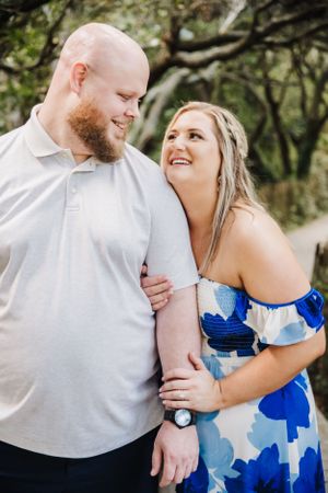 A joyful outdoor portrait capturing a couple's genuine laughter and affection.