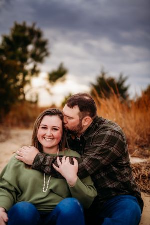 A tender moment captured between a couple during an outdoor photoshoot at sunset.