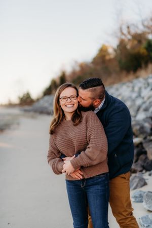 Sweet candid moment between a couple during their coastal engagement session.