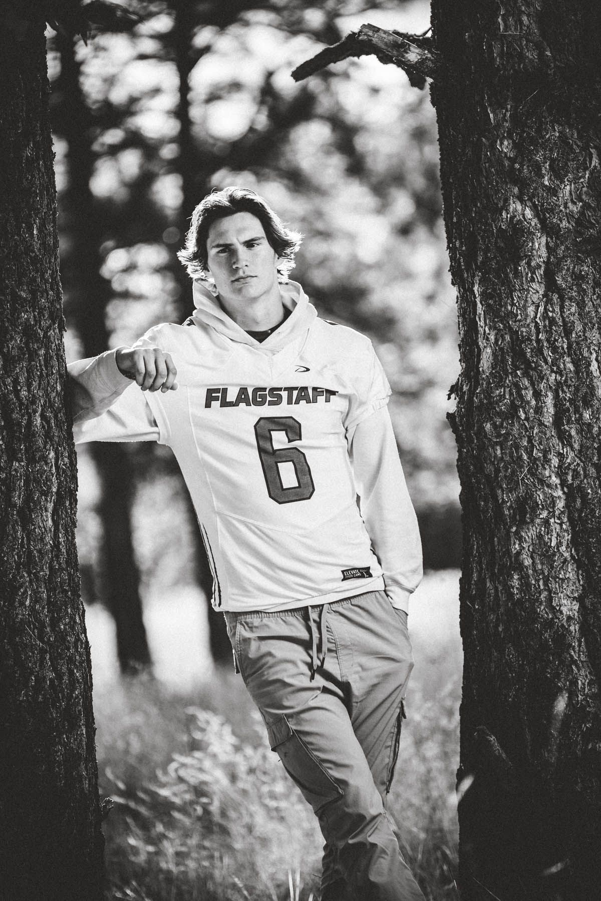 Jake Weidinger poses against a tree for Flagstaff photographer, Sean Openshaw, for his 2022 senior photos.