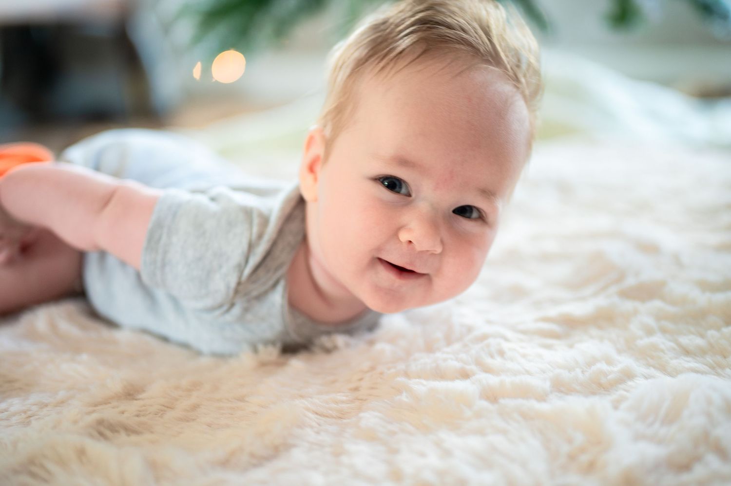 very cute baby on a soft fur rug smiling.