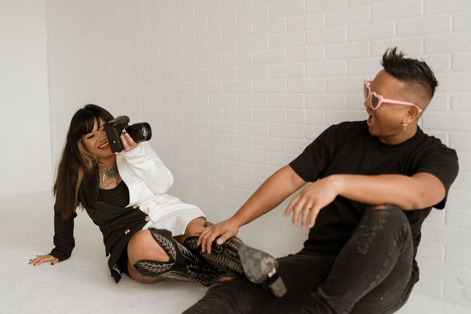 Two photographers in a minimalist studio setting working on a creative photoshoot.