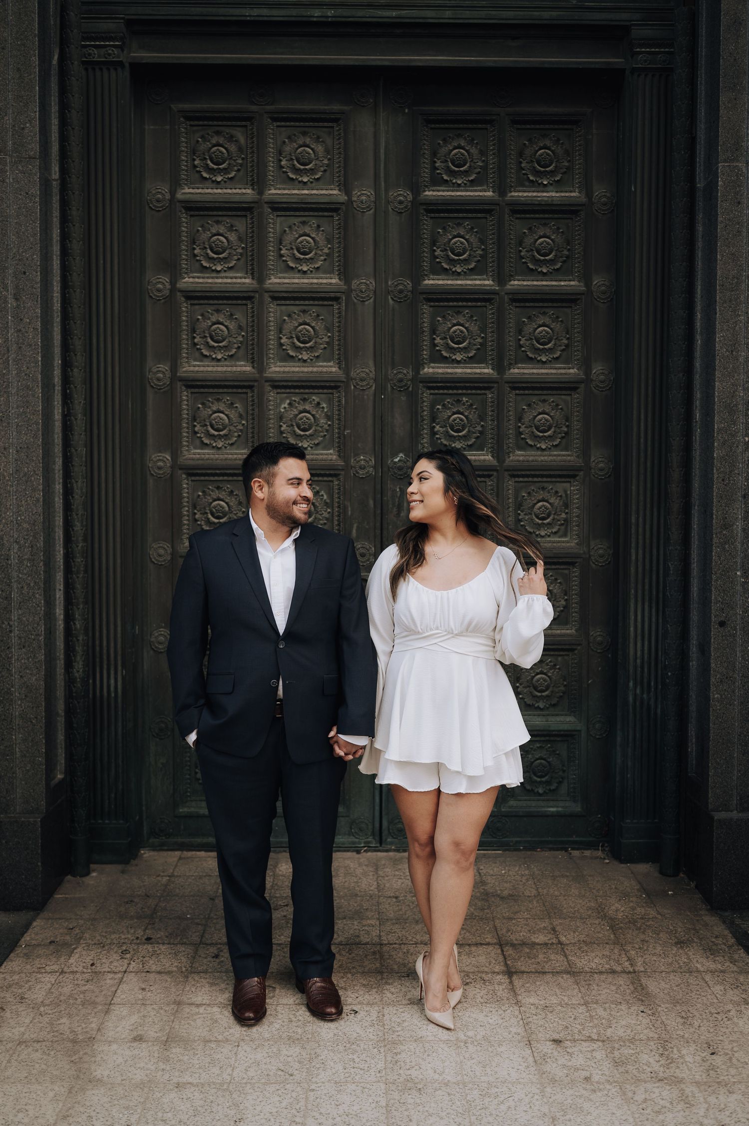 Houston area couple's engagement session. She is wearing white and red-bottom shoes.
