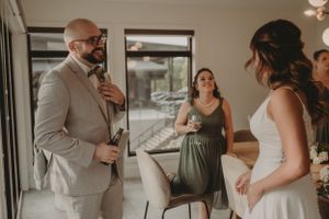 Wedding party members interact in a modern indoor space with natural lighting.