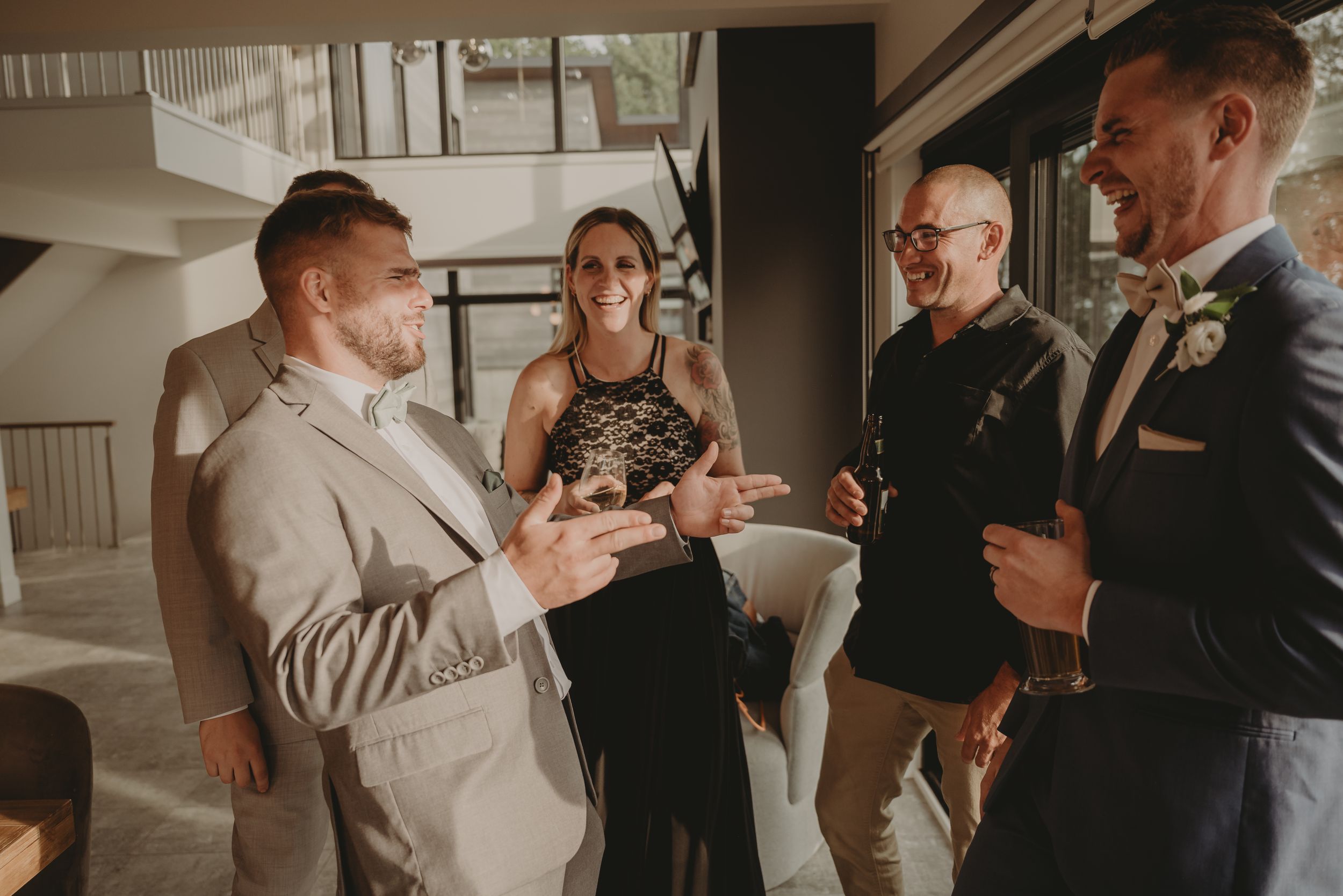 Small group mingles at an indoor wedding reception venue with modern decor.