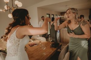 Two wedding guests laugh and share a playful moment at the reception.