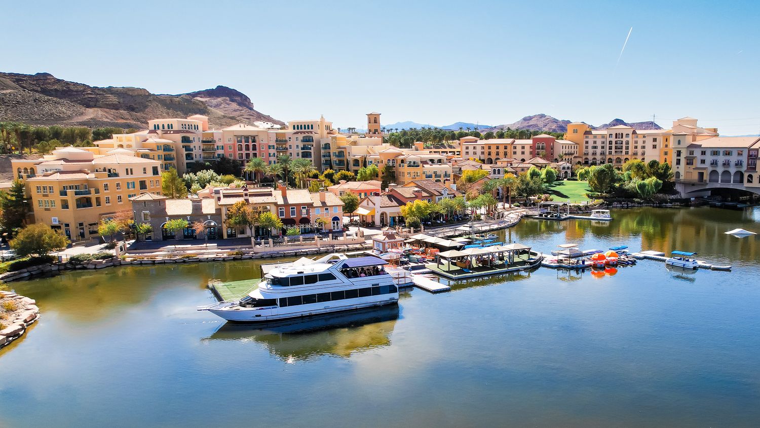 Aerial view of Lake Las Vegas waterfront with Mediterranean-style buildings and docked boats.