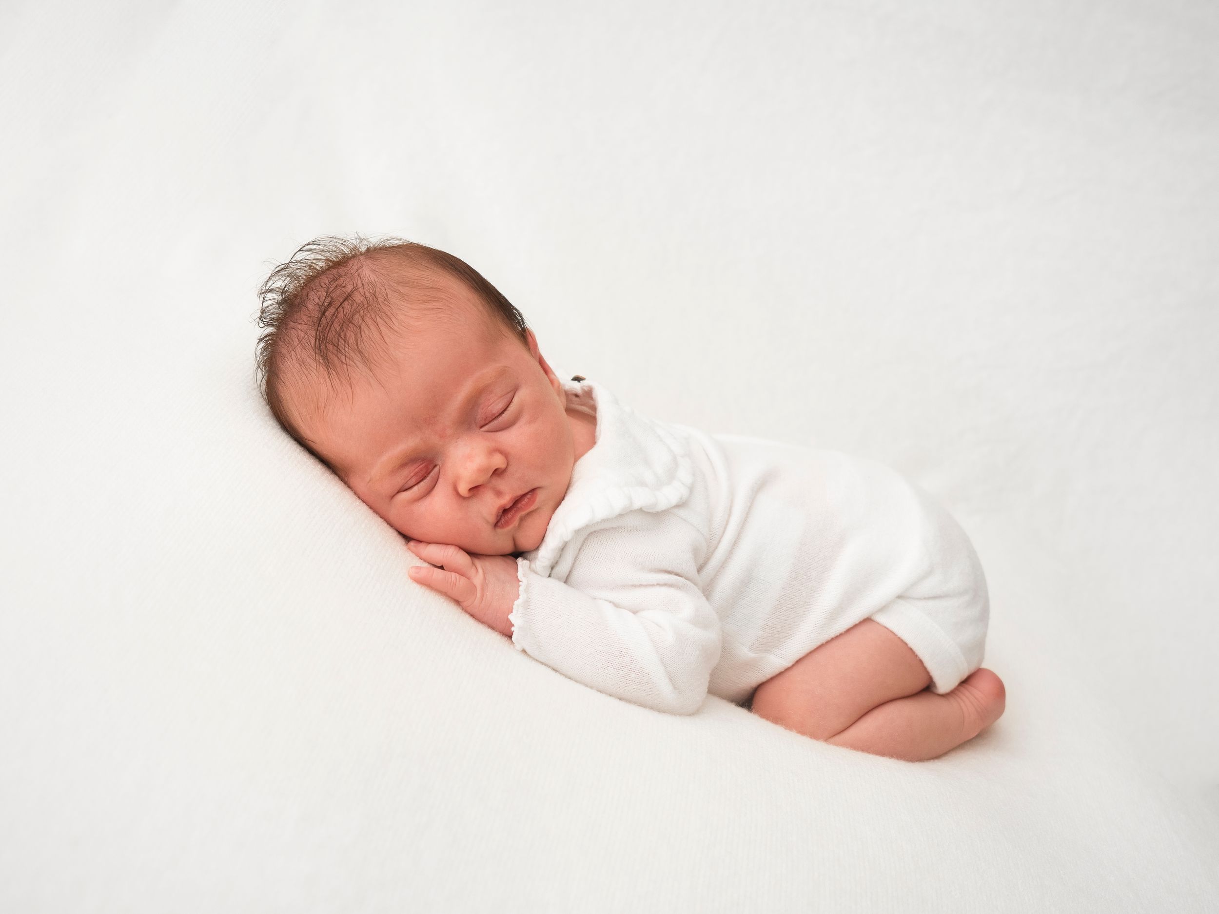 Newborn baby sleeping on white blanket, photoshoot in Didcot by Verity Photography