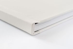 Close-up detail of white photo album binding showing clean minimalist design.