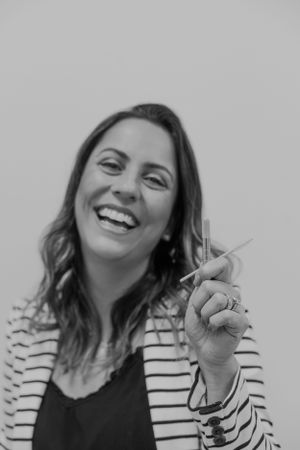 Joyful portrait in black and white showing person in striped jacket gesturing.