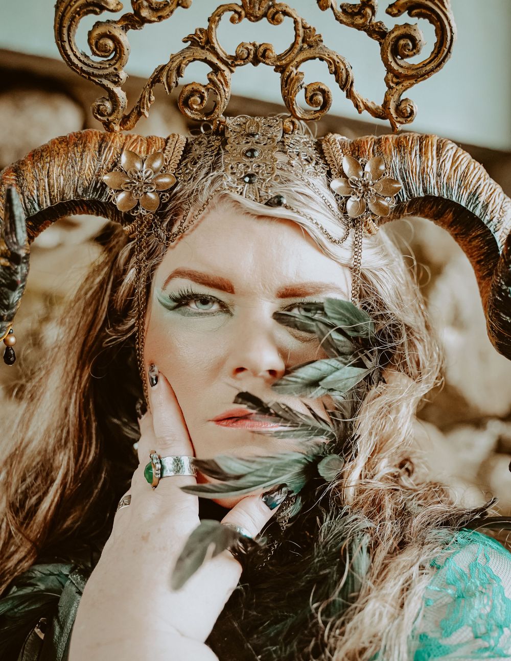 Artistic portrait with ornate crown and green foliage against vintage decorative backdrop.