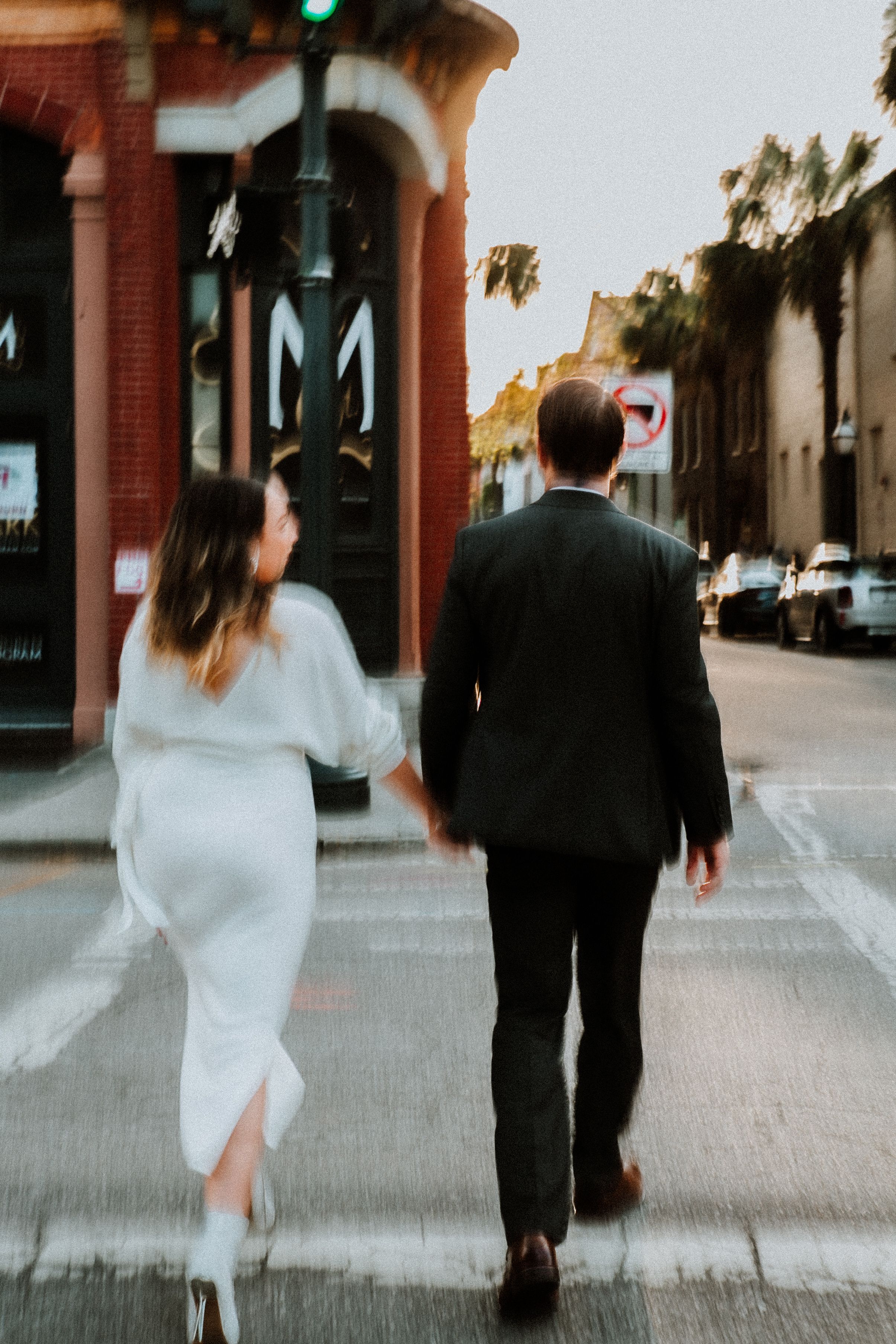 A motion blur photo of a couple crossing the street