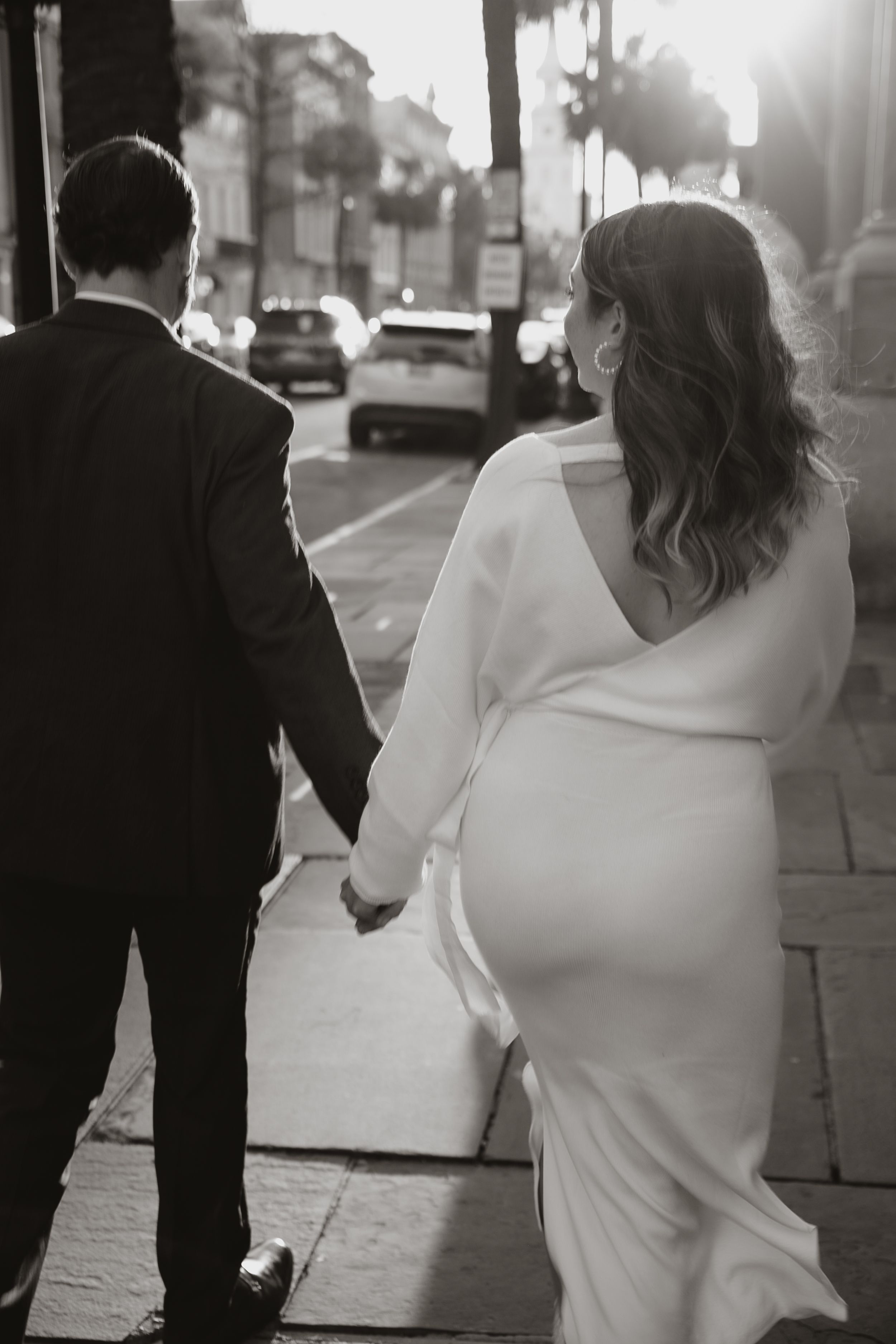 A black and white photo of a couple walking through Charleston