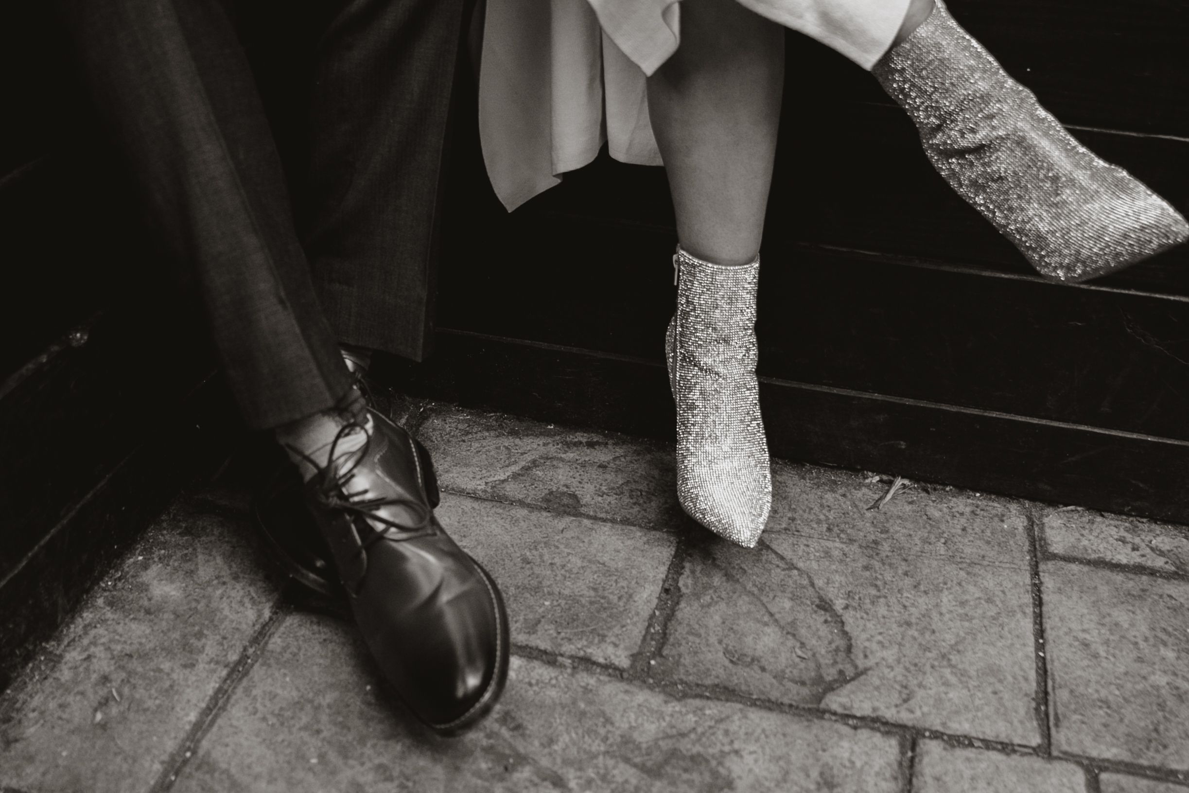 A black and white photo of a couple's shoes