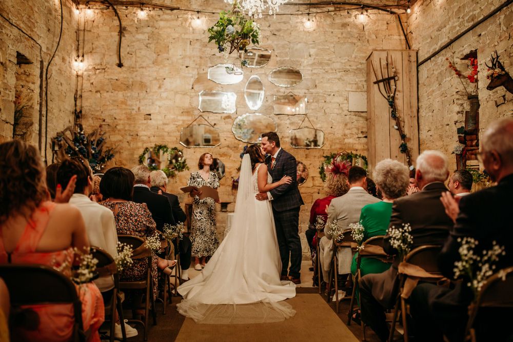 Wedding ceremony in a romantic stone-walled venue illuminated by warm lighting.