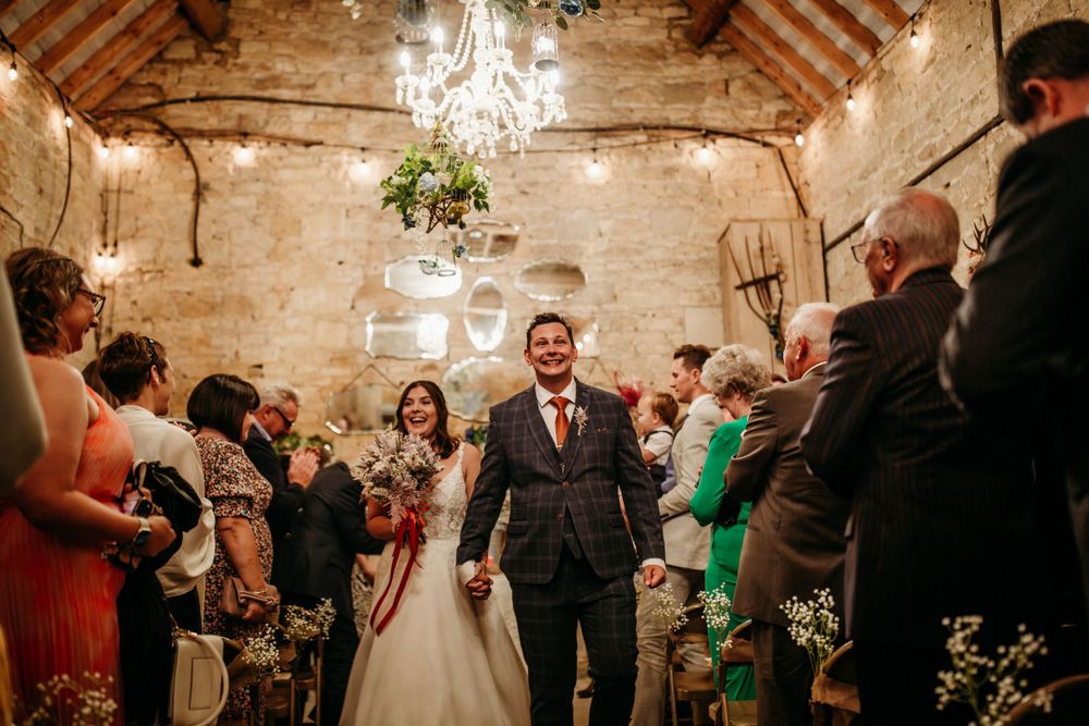 Celebratory moment in a rustic barn venue with chandelier and exposed wooden beams.