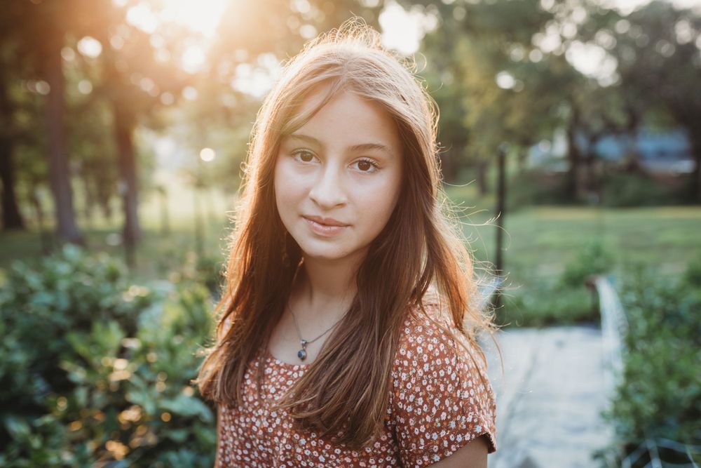 Golden sunset portrait in garden with bokeh lights and floral top.