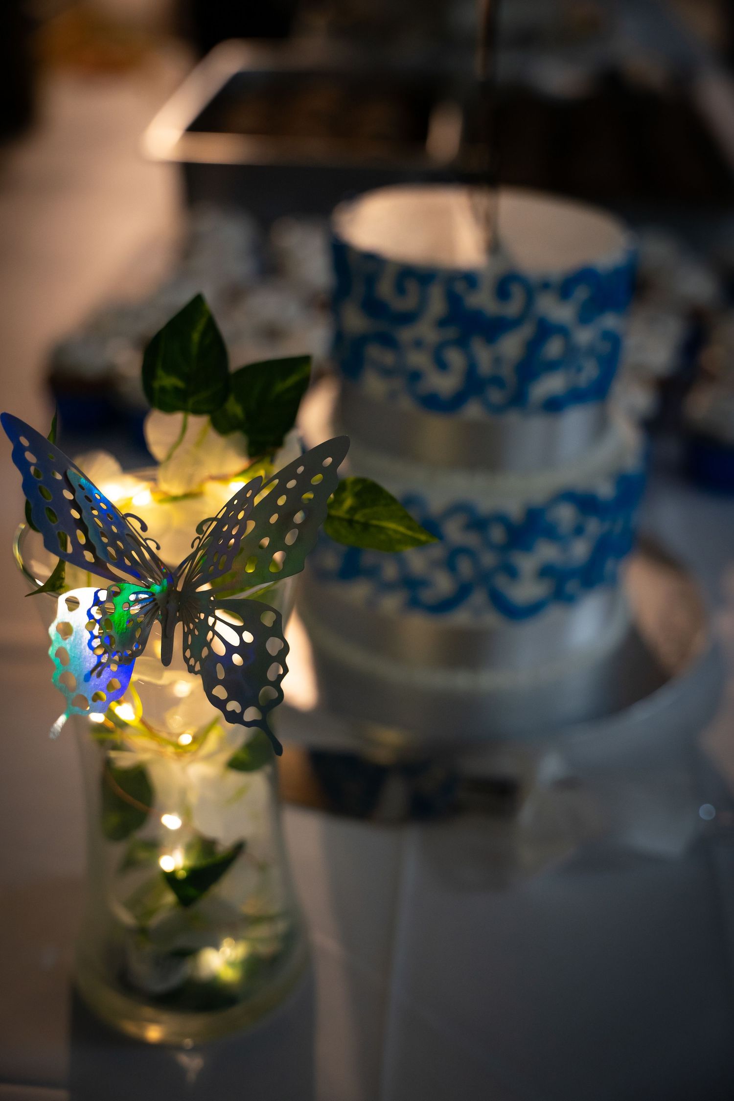 Illuminated blue butterfly decorations creating magical lighting effects at a wedding reception.