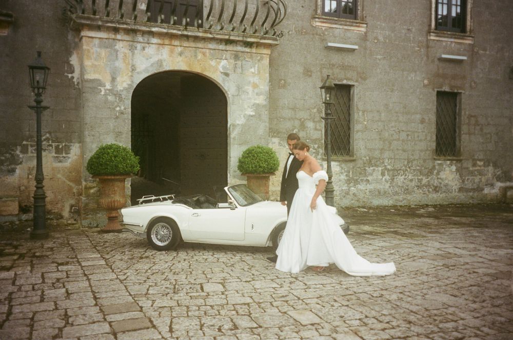 35mm analogue film wedding photography with a vintage car outside Castello monaci, Puglia italy
