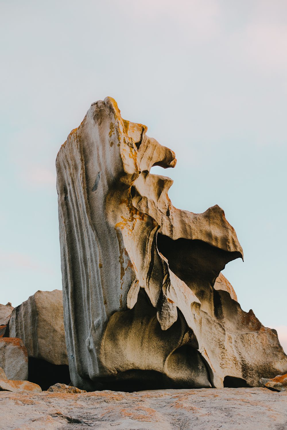 Weathered limestone rock formation against pale sky showing natural erosion patterns and textures.