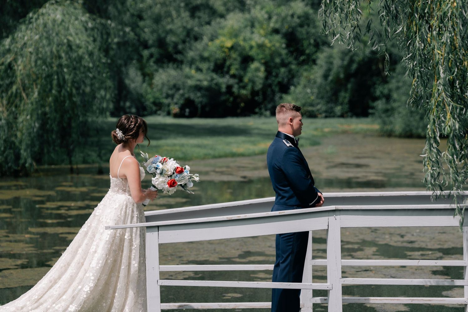 Couple sharing a moment on a white bridge surrounded by weeping willows.
