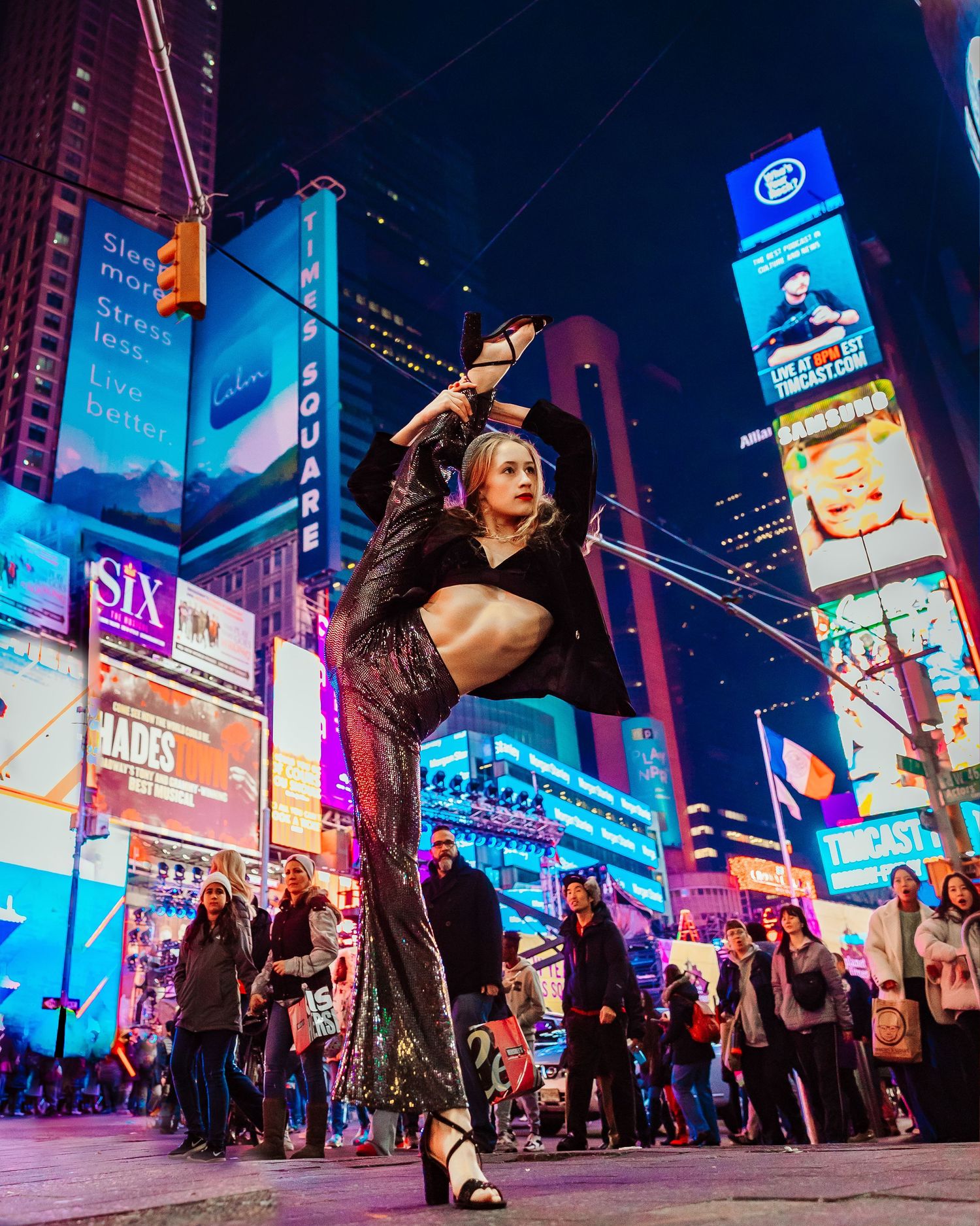 Dynamic street dance performance captured in Times Square with bright neon billboards.