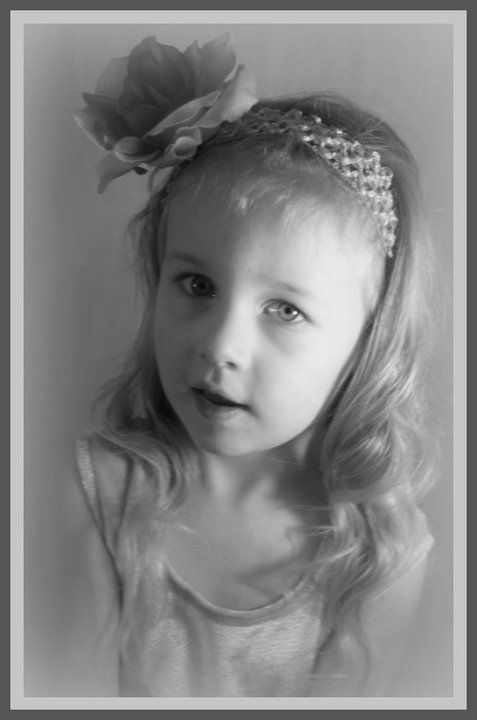 Black and white portrait with flower headpiece and sparkly hair accessories.