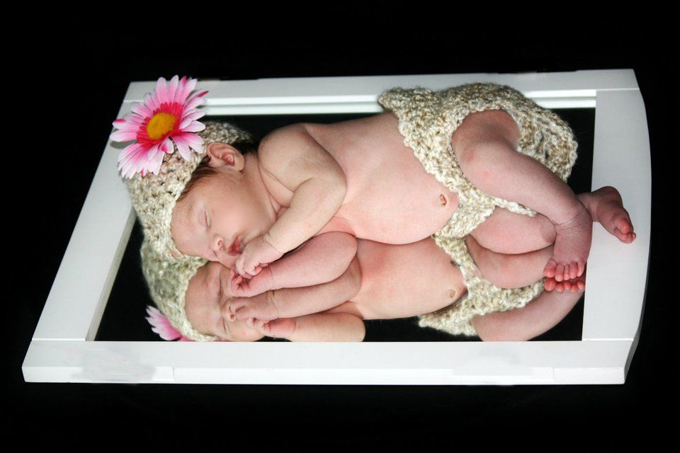 Delicate lace and floral accents frame tiny newborn details in soft lighting.