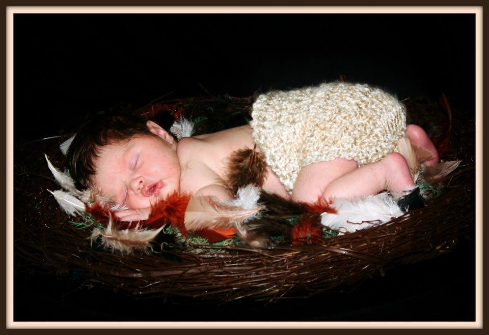 Artistic black and white series showing a sleeping infant in a dark setting.