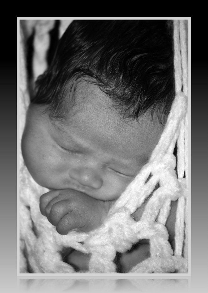 Black and white artistic series of newborn details in soft lighting.