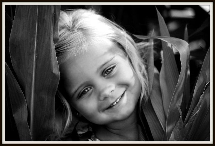 Black and white portrait series showing playful expressions through foliage.